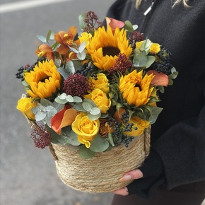 Композиция в сумке "Тональность" из подсолнухов, калл, ягод вибирнума, лимонных роз, скиммии и орхидеи в Дубне